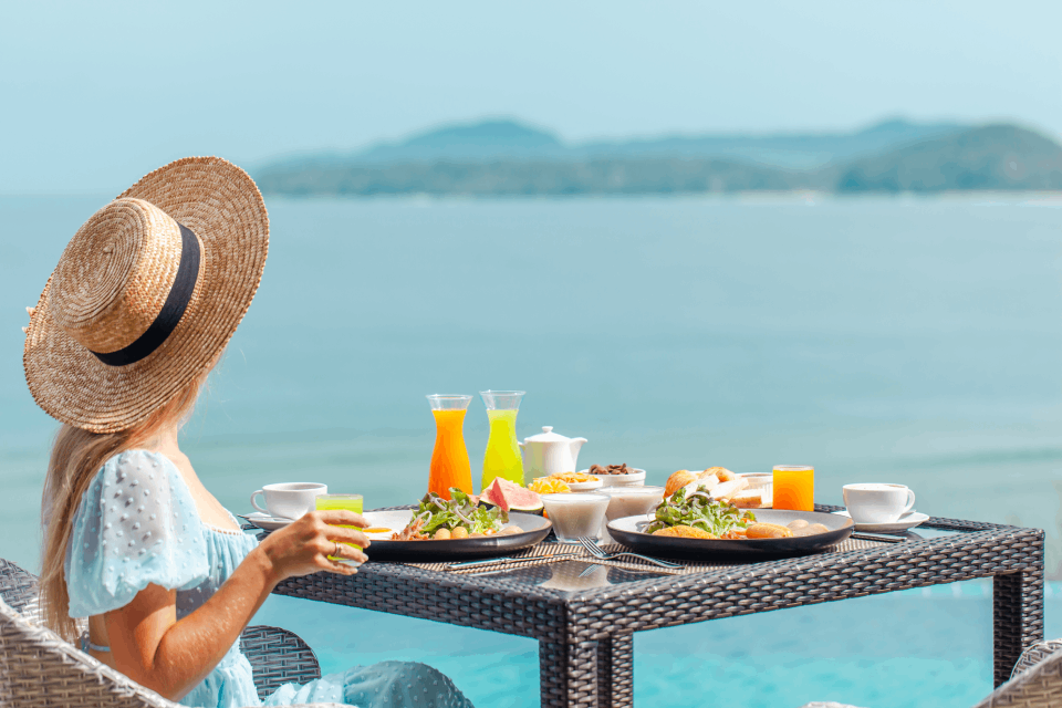 Mujer desayunando mientras mira al mar